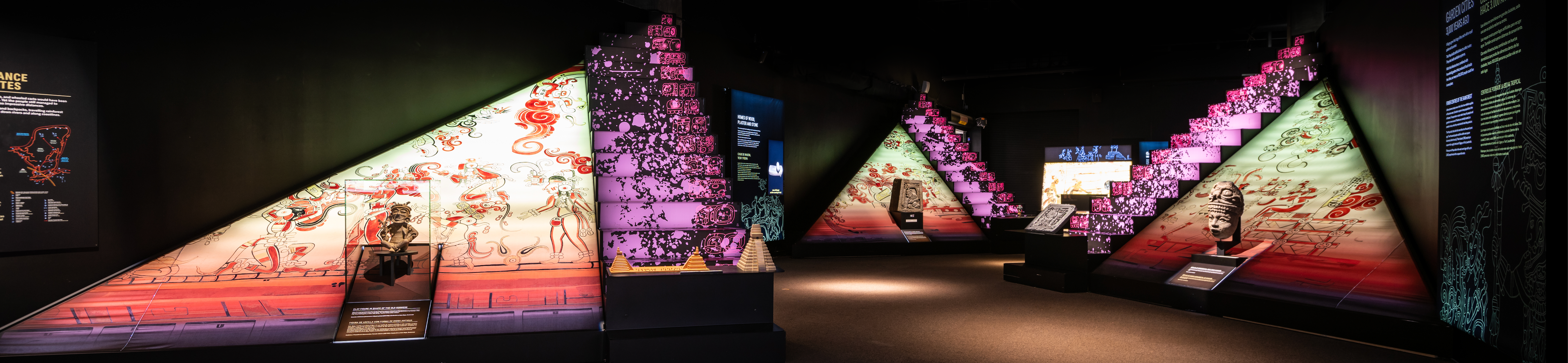 Colorful pyramid-shaped displays inside the exhibition Maya: The Exhibition