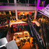 Aerial view of carnival themed cocktail party in the Ahmanson Building with purple and amber lighting at dusk