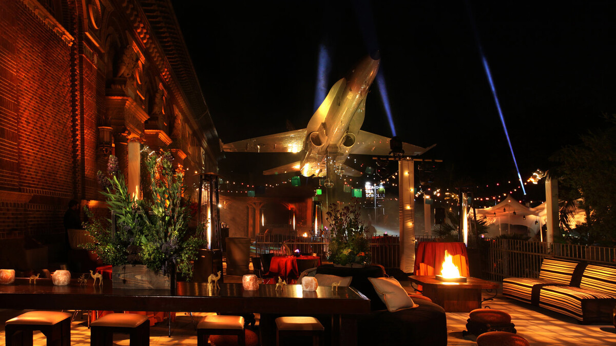 North Patios at Night with lounge furniture and fire pits beside F/A-18A Hornet