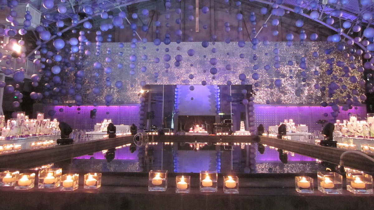 Wallis Annenberg Building Big Lab Wedding adorned with purple lantern chains hanging from the ceiling and candles along the fountain