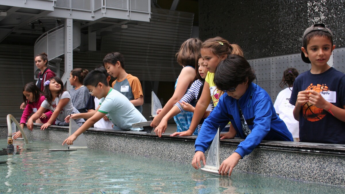 Youth participating in a field trip program, testing boats in the Water Works pool