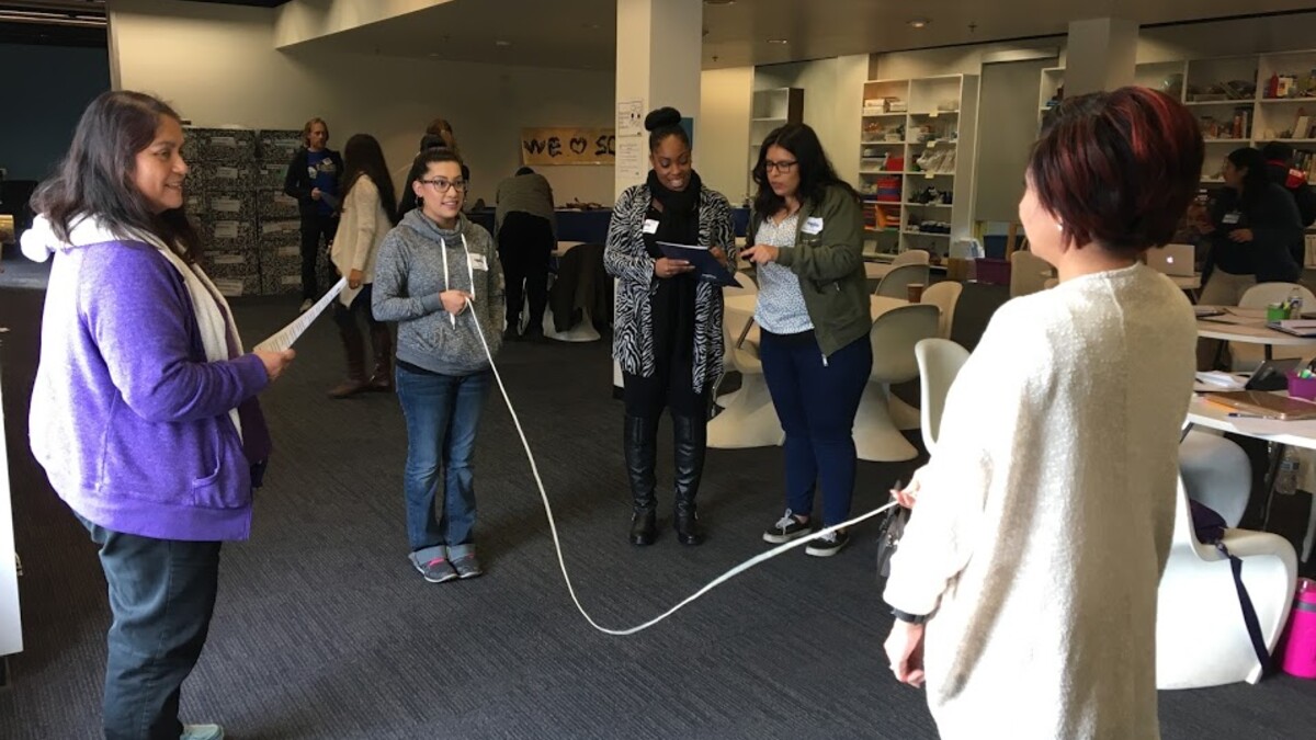 Teachers holding long string to participate in a hands-on project in a Professional Development program
