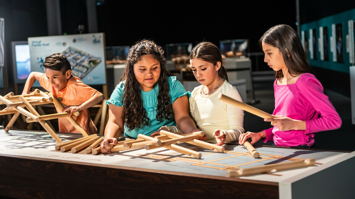 Children try building Leonardo da Vinci's self-supporting bridge inside the da Vinci exhibition.
