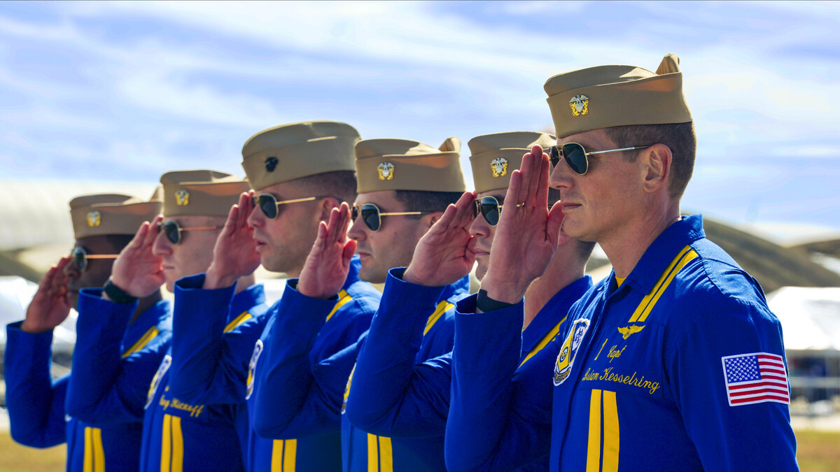 Blue Angels pilots, all in uniform, salute. 