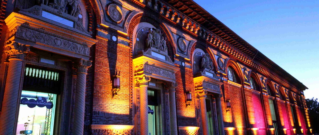 California Science Center rear entrance and North Patios illuminated in amber and pink uplights